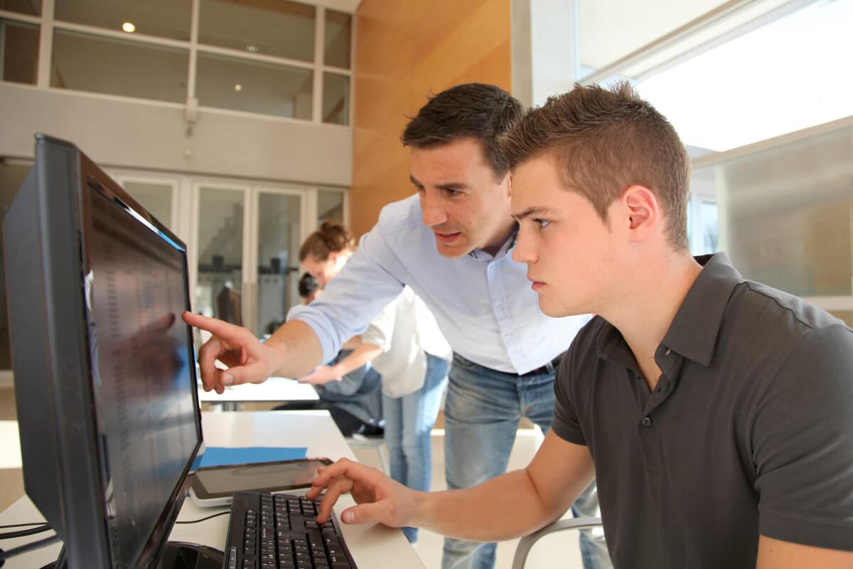 apprenticeship providers - Teacher and student working on computer